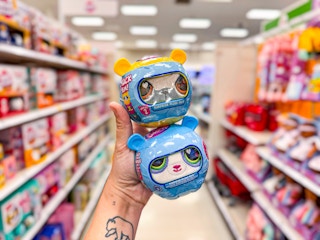 hand holding two littlest pet shop plushes in target aisle