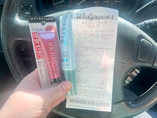 hand holding maybelline makeup and a walgreens receipt