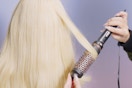 a woman using a wavytalk round brush styler