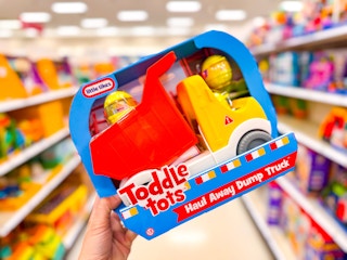 hand holding a little tikes dump truck in a target aisle