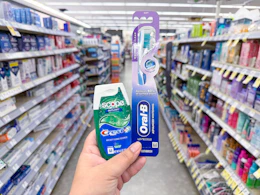 hand holding crest and oral-b products in walgreens