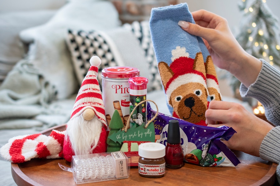 A pair of Christmas socks with dogs on them next to Christmas goodies