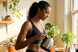 a woman making coffee wearing a puma sports bra