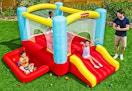Lifestyle image of the Fisher-Price Bouncemania Inflatable Bounce House being used outdoors (3 children 1 adult)