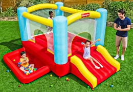 Lifestyle image of the Fisher-Price Bouncemania Inflatable Bounce House being used outdoors (3 children 1 adult)
