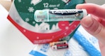 hand holding a tube of holiday cocoa chapstick in front of an amazon package and the 12 days of chapstick advent calendar