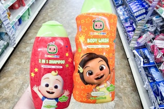 person holding a bottle of cocomelon body wash and a bottle of cocomelon shampoo
