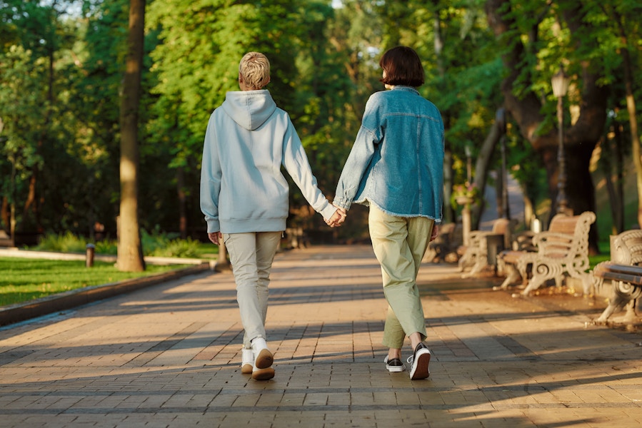 Two people holding hands and taking a walk in a park