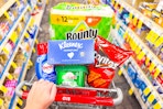 person pushing a cart with bounty, kleenex, cascade, persil, and doritos in it