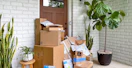 plants and stacks of amazon boxes and packages on front porch