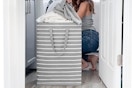 woman taking clothes out of large laundry basket