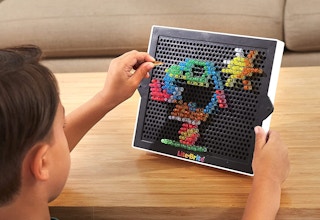 A boy playing with a Lite-Brite.