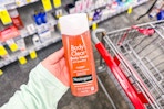 person holding a bottle of neutrogena body wash by a cart