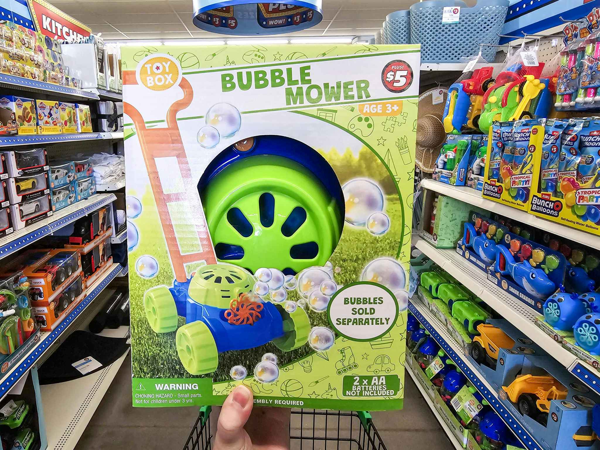 person holding a bubble mower in an aisle