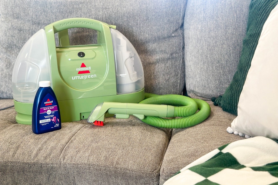 a Bissell Little Green carpet cleaner and cleaning solution on a sofa 