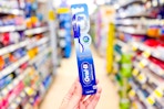 hand holding an oral-b essential clean toothbrush 