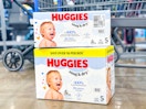 two boxes of huggies snug & dry diapers on floor in front of walmart cart