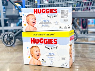 two boxes of huggies snug & dry diapers on floor in front of walmart cart