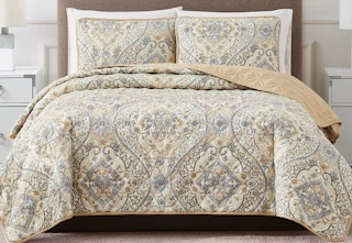 tan design quilt set displayed on a bed