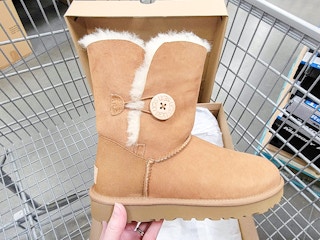 hand holding a brown ugg boot