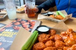 Wings and fountain drinks on a table in a Buffalo Wild Wings restaurant.