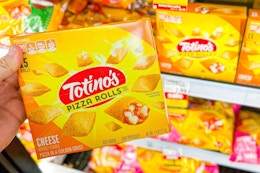 hand holding a box of totino's pizza rolls