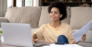 person with documents and laptop filing taxes online