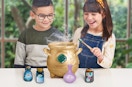two kids playing with a Magic Mixies Misting Cauldron