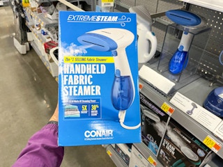 hand holding box of conair hand held fabric steamer at walmart