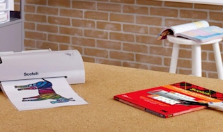 a thermal printer on a table with a pack of thermal pouches