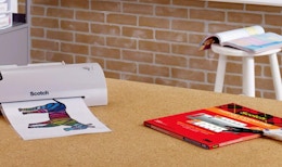 a thermal printer on a table with a pack of thermal pouches