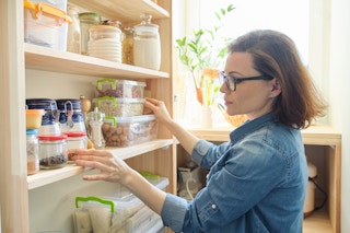 cheap meals that go a long way - Woman looking at pantry