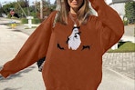 a woman wearing a halloween sweatshirt