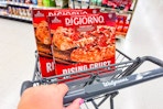 person pushing a cart with 2 digiorno pizzas in it