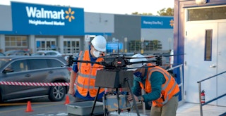 two people outside walmart preparing drone for delivery feature