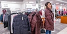 person trying on winter coats at macys