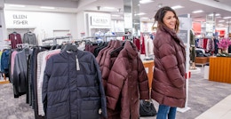 person trying on winter coats at macys
