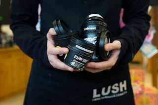 a lush employee holding a bunch of empty containers     