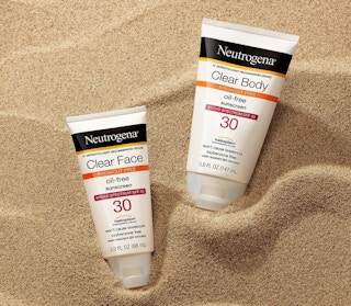 two sunscreen tubes in sand