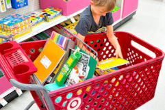 child putting a notebook in a target cart with school supplies