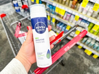 hand holding a nivea shave gel bottle over a cvs cart