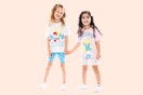 Two toddler girls holding hands wearing a Smurf lounge set (tee + bike shorts)
