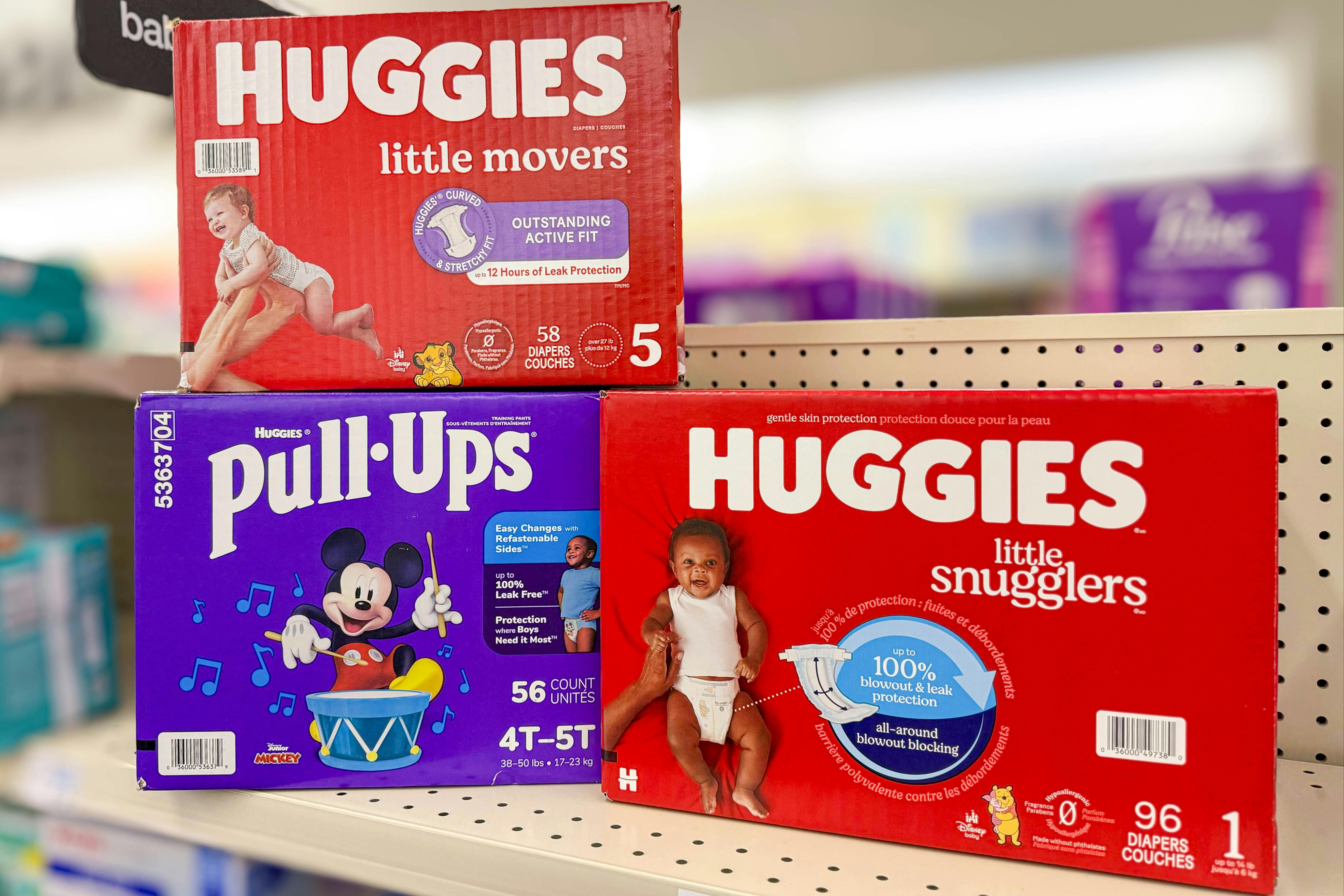 three huggies diaper boxes on a store shelf