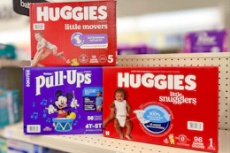 three huggies diaper boxes on a store shelf