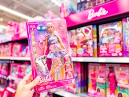 Barbie doll being held up in toy section at Walmart