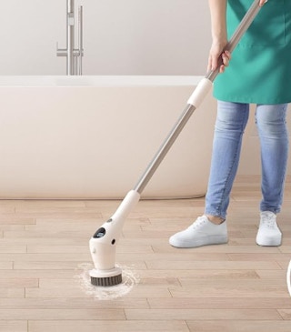 a person cleaning a floor with a scrubber