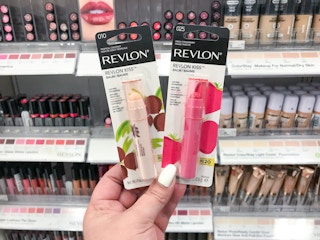 hand holding 2 revlon kiss lip balm at target