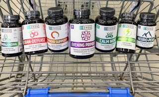 zhou nutitrion health supplements in a blue walmart cart with floor as backgroun