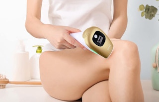 a person using a hair removal device on their legs