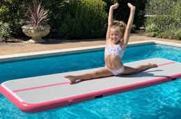 Lifestyle image of a girl using an inflatable gymnastics mat in the pool (created by banana studio)